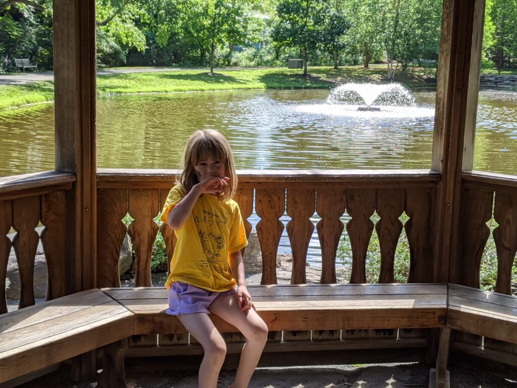 A girl sits in the gazebo at Green Spring Garden