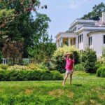 A girl shades her eyes as she looks out over the gardens in front of a plantation house at Oatlands Plantation in rural Virginia